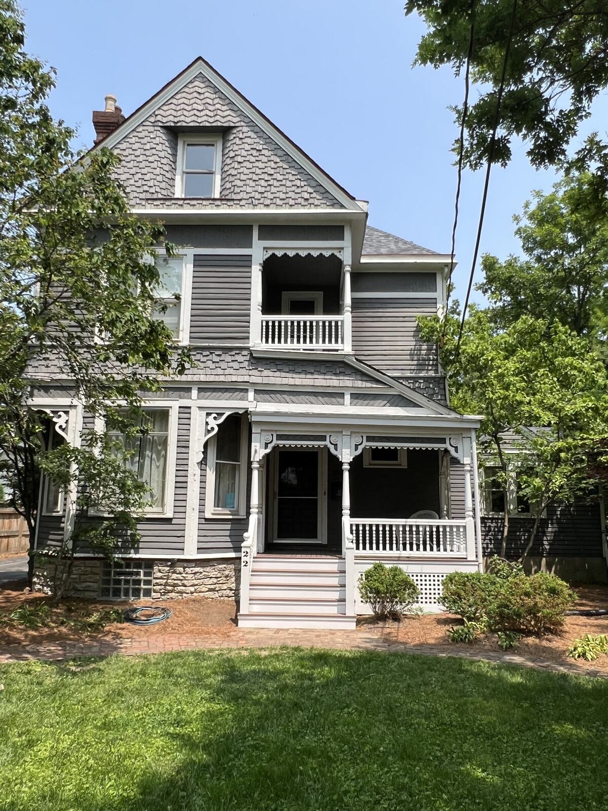 a grey victorian home with white trim